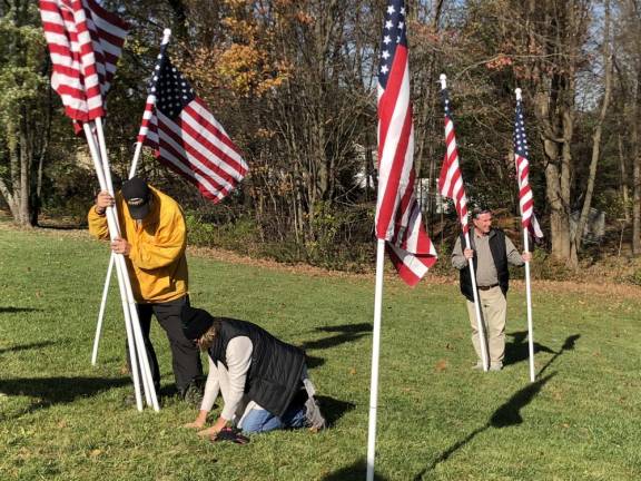 Karen Sabyan helps Bob Asaro find the cup in the ground to hold a flag. (Photo by Kathy Shwiff)