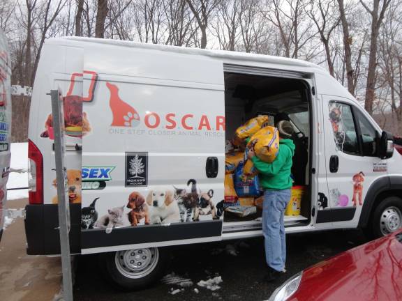 Mohawk House goes to the dogs for O.S.C.A.R. fundraiser Photos by Scott Baker Lou Verile Jr. of Montague, volunteers to help load the O.S.C.A.R. van with newly-donated supplies.