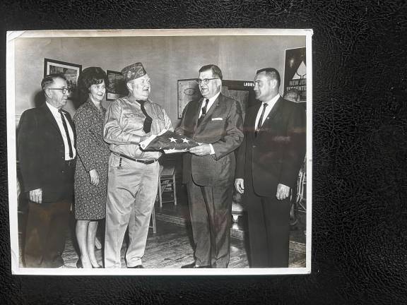 Looking back: VFW Post 7198 A flag that flew over the White House is presented to Veterans of Foreign Wars Commander George Breslin by lawyer Louis Wallisch Jr. to be flown at the post, 196 Lincoln Ave., in the 1950s. From left are Charles Andrews, Nancy Mays, Breslin, Wallisch and Councilman Joe Bender, post founder. (File photo by Ann Genader)
