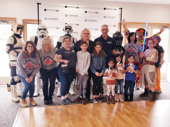 April Fools’ Family Fun event organizers, attendees, volunteers and characters pose for a photo.