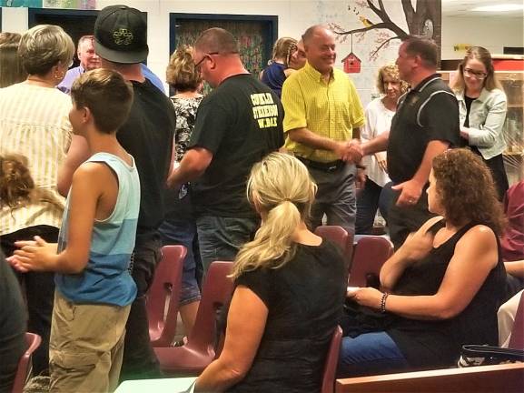 Greg Bailey is congratulated by the audience at the Aug. 20 BOE meeting.