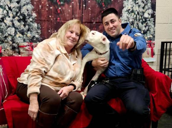 Reina shows some affection to animal shelter volunteer Shirley Parrello while Robert Hahn holds her.