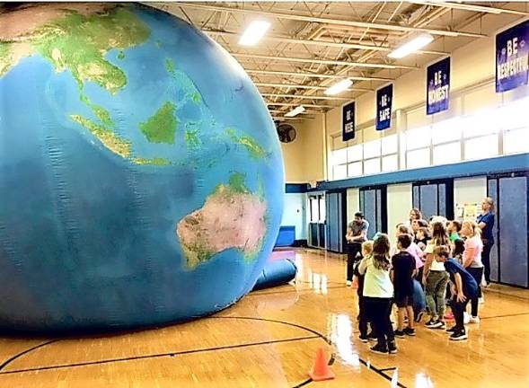 Paradise Knoll students learn about the earth with the help of a large balloon.