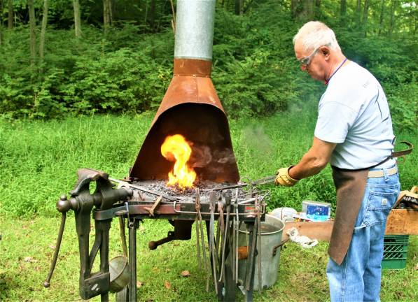 [Wyckoff Blacksmith Gaspar Lesznik conducts a field demonstration of 19th century metal work at the Long Pond Ironworks State Park in Hewitt on Saturday. Charles Kim photo]