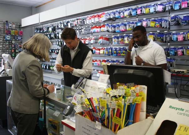 Computer Discount of New Jersey isn't in it alone Photo by Linda Smith Hancharick Mike Russo, center, helps a customer while Taylor Jennings, right, answers a customer's call at CDNJ this week. This local business highlights another local business each month so they can both benefit.