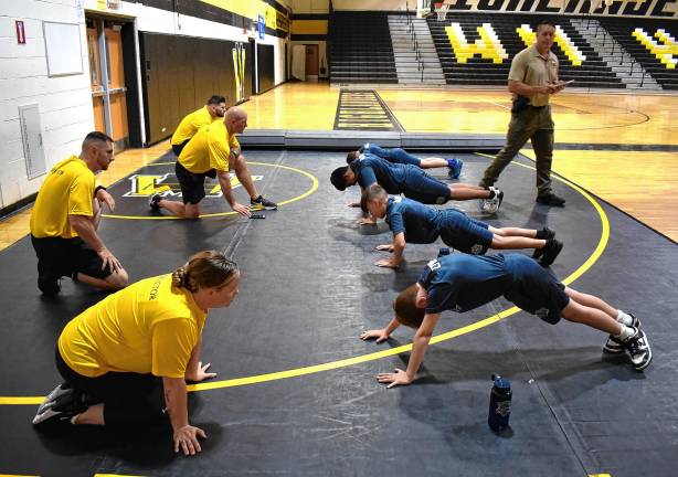 Junior Police Academy grows Instructors watch the cadets do push-ups.