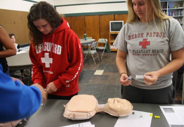 Melanie Dowling, left, and Peyton Porch, recent graduates of West Milford High School who both will be attending Misericordia University in Pennsylvania in the fal and majoring in health sciencesl, learn how to assemble a Narcan container before administering it.