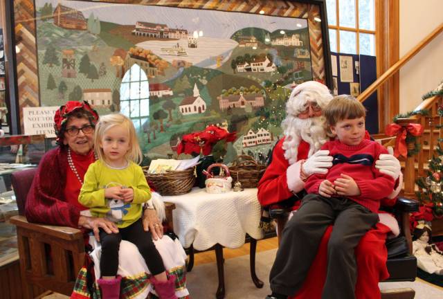 Santa and Mrs. Claus, and their alter egos, Mary and Bob Kochka, welcome Avery Poplawski, 3, and big brother Ethan, 7, to the West Milford Museum Christmas festivities.