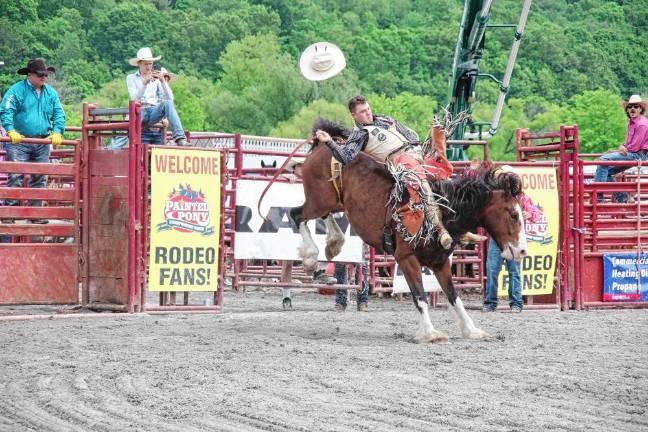 Rodeo is Saturday at Green Valley Farms A rider loses his hat but not his grip during the saddle bronc riding competition.