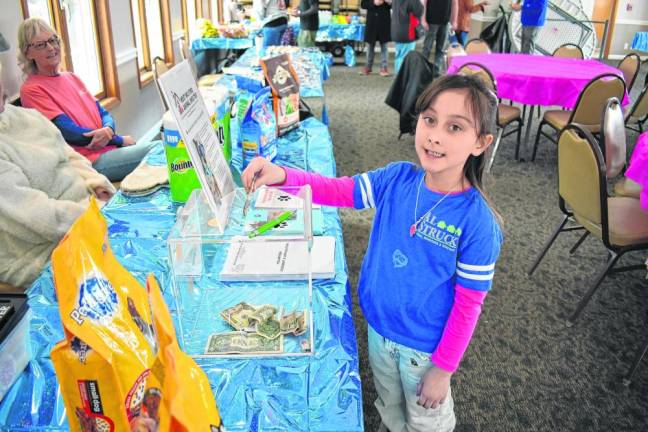 A girl makes a donation to the West Milford Animal Shelter.