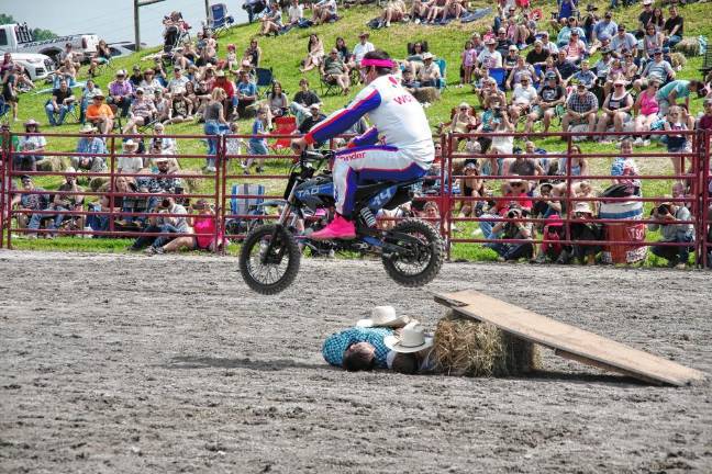 Rodeo is Saturday at Green Valley Farms Rodeo clown Scotty Too Hotty jumps over two cowboys during a motorcycle stunt.