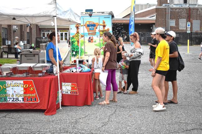 Community gathers for National Night Out DeMarco’s Pizzeria & Restaurant sells food at the event.