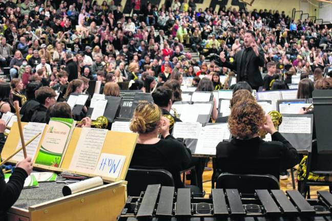 Matt Gramata directs a band performance in the high school gym.