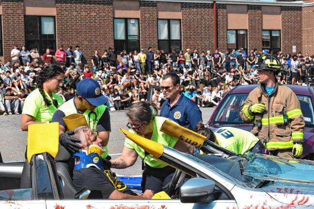 Simulated crash meant as warning Medical personnel treat a driver in the simulated crash.