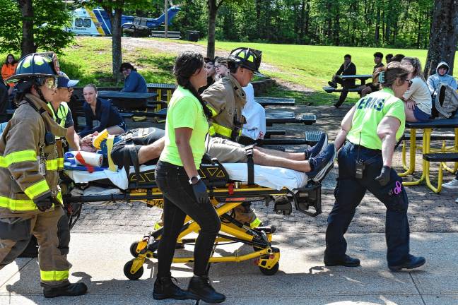 Simulated crash meant as warning First-responder move an actor portraying a person injured in the accident.