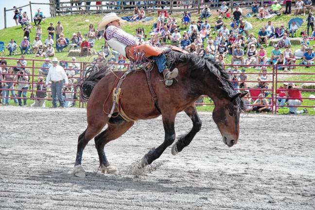Rodeo is Saturday at Green Valley Farms A rider leans back during the saddle bronc riding competition.