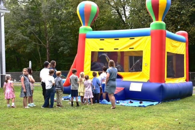 Church celebrates centennial Children line up to play in a bounce house.