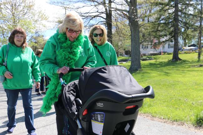 Patti Kane, wife of Danny Kane, is seen here in her tradmark green boa. This year, though, is special for her as she pushes her new grandson during the event.