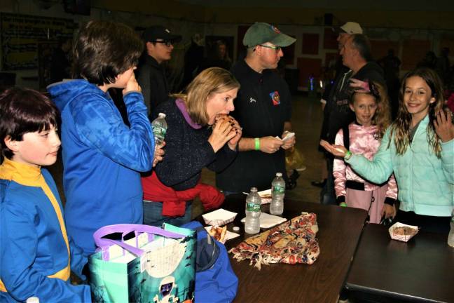 Spooktacular attendees, (left to right) Jonah Wells, Matt, Noelle, and Jay Riesenman, Heather Lahr and Isabel Riesenman have some food from one of the vendors.