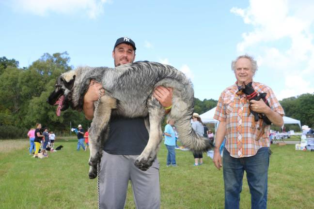 Pooches strut their stuff in Walk-a-Dog-athon Sehir Izejrosky of Hewitt, left, hefts Rocky, while Peter Davis, also of Hewitt, cradles Cricket. Rocky tied in first place for largest dog with Wyatt, owned by Virginia Moore. Cricket was snout to snout with Stephanie Sullivan's Dolce for the title of smallest dog.