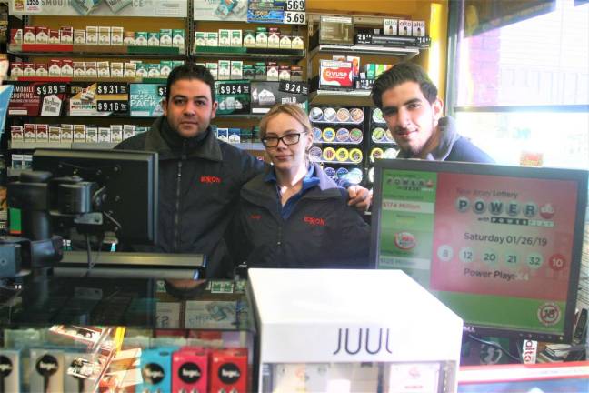 Charles Kim photo Hweitt Tiger Mart employees Loiy Mohammed, Kasey Spurlock, and Tareq Emrami stand next to the lottery machine that delivered a winning $600,000 Cash 5 ticket to a local man Sunday.