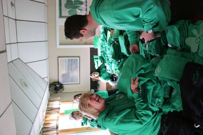 Patti Kane hands out the trademark green Irish Whisper shirts at the event April 30.