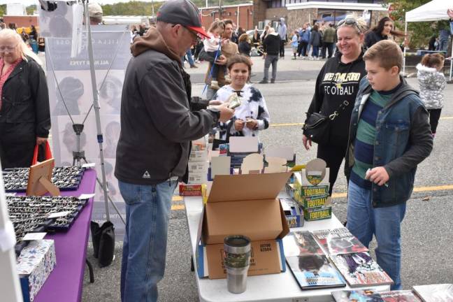 Victor Padilla, 12, of West Milford purchases sports trading cards from a vendor at the 27th annual Autumn Lights Festival. He was with his sister, Olivia, 8, and mother, Bernadette. (Photo by Rich Adamonis)