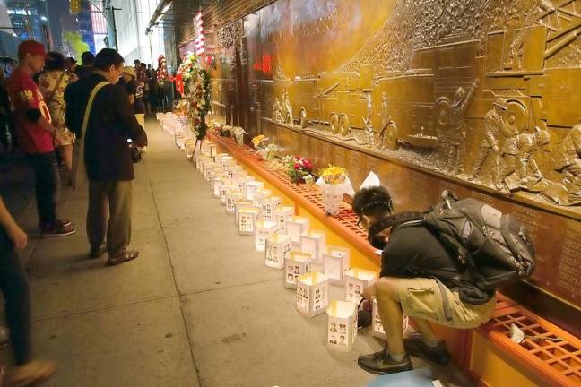 People pay their respects on the 13th anniversary of 911 outside FDNY Ten House located across the street from the World Trade Center. Ladder and Engine Co. 10 lost five members on that day. Photo by Robert G. Breese.