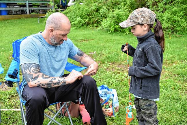 ‘Fishing and family fun’ Ed Zimmerman helps his daughter, Luna, get ready for the annual Kids Fishing Derby at Bubbling Springs Lower Lake.