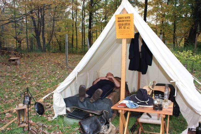 History comes alive at Long Pond Ironworks Cpt. Walter Dewey catches a few winks in the authentic camp site at Long Pond Ironworks. The poster on tent reads "Recruits wanted. Come on, men! To the call." For more photos of the reenactment, go to westmilfordmessenger.com.