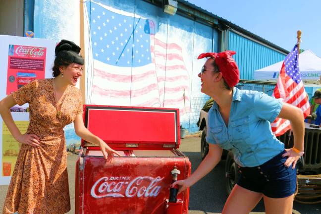 Have a Coke and a smile! Members of the Army Air Forces Historical Association are dressed in period costume from the World War II era giving out old fashioned bottles of Coke.