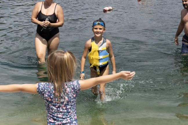 Going the distance Martina Keeney greets her sister, Isla, 8, as she finishes the distance swim. Isla was the youngest participtant. (Photo by John Caggiano)