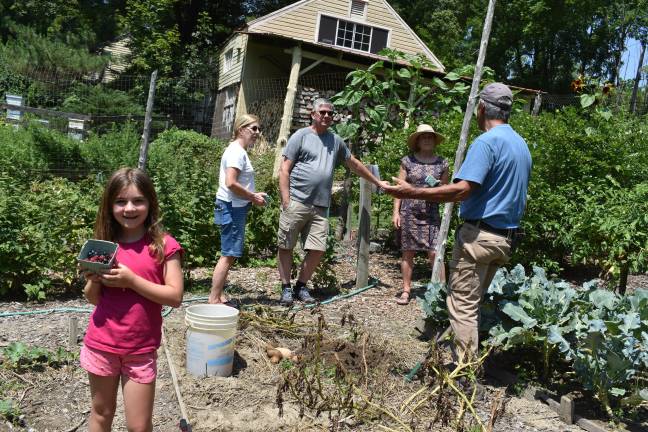 Local green thumbs harvest top honors Larry Mansour talks potatoes with visitors to his Warwick, N.Y., garden while a young visitor shows off her berry haul. (Photo by Becca Tucker)