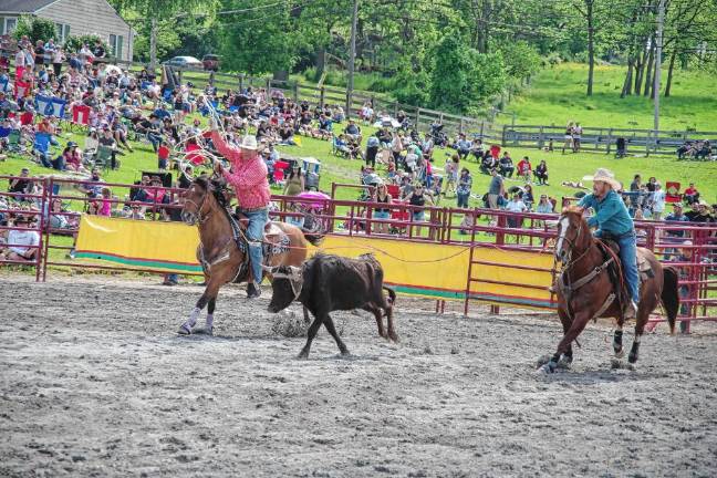 Rodeo is Saturday at Green Valley Farms Teammates Morgan Anderson and Shawn Quinn in action during the team roping contest.