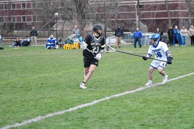 West Milford’s Nash Appell carries the ball as Kittatinny’s Greyson Lobb keeps pace in the April 4 game won by the Highlanders, 7-3. Appell scooped up seven ground balls and made two assists. (Photos by George Leroy Hunter)