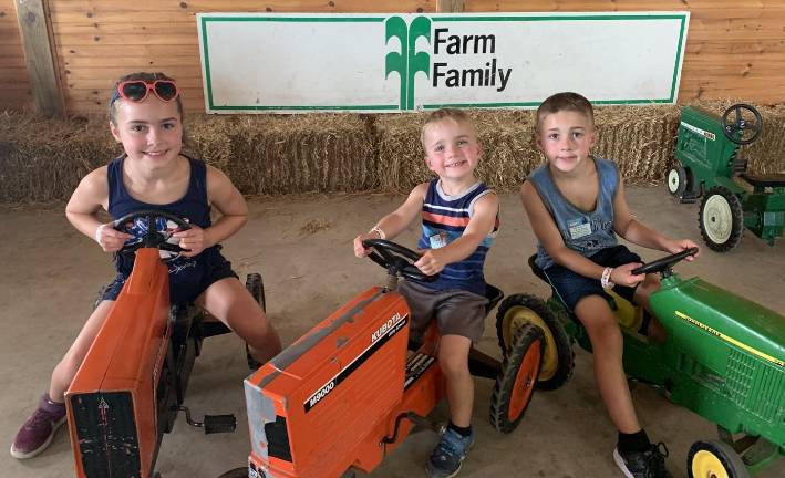 State Fair fun Cami, Chase and Logan Morrow have a great time as their grandmother and parents watch them ride min tractors in the Familyl Fun section of the State Fair on Sunday, Aug. 4.