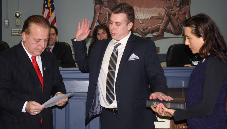 I do solemnly swear... Newly minted Councilman Tim Wagner, center, is joined by his wife, Daina, as state Senator Joseph Pennacchio gives the oath of office to him. Wagner is new to the township council.
