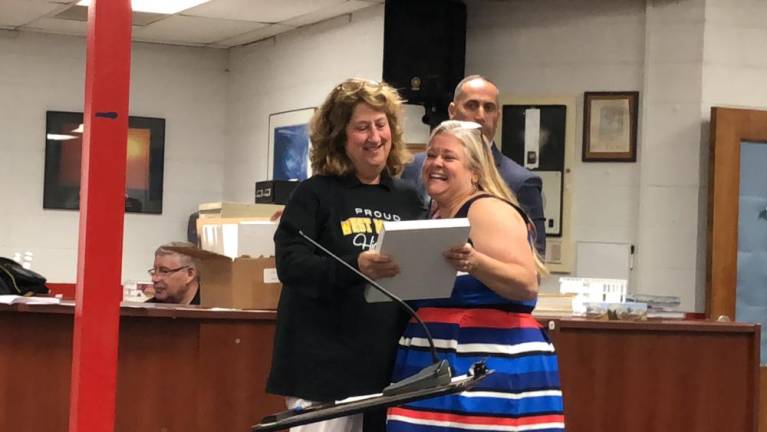 School board president Kate Romeo, right, presents a plaque to West Milford High School social studies teacher Claudia Ney, who retired after 35 years with the district.