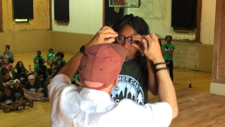 Campers given free glasses John Jonas, co-president of Jonas Philanthropies, adjusts a new pair of glasses for Ruben Benitez at Camp Vacamas in West Milford on Wednesday, July 26.