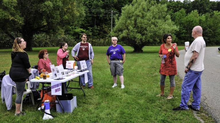 Sun shines on the dog walkers Shelter volunteers manned the registration table.