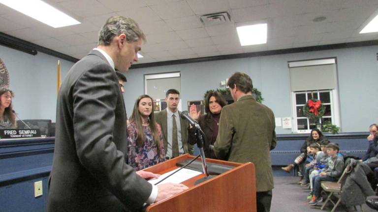 Township Council reorganizes with two new members, president PHOTOS BY ANN GENADER Councilwoman Andrena Pegel, with her husband holding a Bible and their children looking on, responds as New Jersey Assemblyman Jay Webber administers her oath of office.