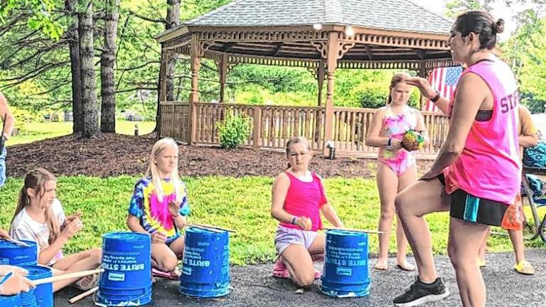 West African drumming lesson DR2 Amanda Roth, right, was the music director at the Bubbling Springs Day Camp this summer. As a child, she attended the camp, then became a counselor there.