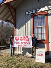 Matt Klemchalk, left, manager of the Newfoundland Train Station, and John Sobotka, a train coordinator with Operation Toy Train, advertise the new stop on the collection train. (Photo by Kathy Shwiff)