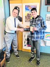 Macopin Middle School Principal Greg Matlosz congratulates eighth-grader Truman Kane, who received the Richard Gilder Prize. It honors promising history students. Truman received a copy of ‘1774: The Long Year of Revolution’ by Mary Beth Norton. (Photo provided)