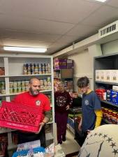 Scouts sort and label food that they collected Nov. 12 at Our Lady Queen of Peace Church’s food pantry in Hewitt. (Photos provided)