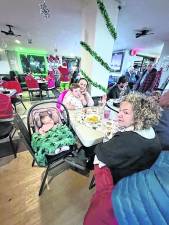 The Mazzola family with children ages 3 and 5 months are enjoying dinner with the Grinch.