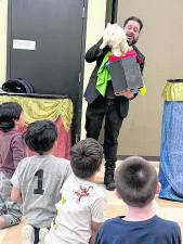 Mr. Magico pulls a rabbit out of a box.