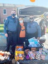 Despite the inclement weather, the West Milford Police Department held its annual Trunk-or-Treat event at police headquarters last Saturday. Pictured from left to right with the Halloween goodies are: Officer Michael Weber, Officer Amy Antonucci and Officer Jason Lowenfeld. Photo provided by Rita Casey.