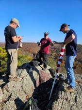 Anthony Rogosich, John Zimmermann and George Wilde replace a tattered American flag at the top of Moe Mountain in Upper Greenwood Lake on Oct. 30. Jennifer Tebbetts Hoffman accompanied them a day after Anthony and Cathy Rogosich saw the torn flag. Solar lights also were attached to the site. (Photo provided)
