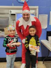 Jared Fowler, principal of Upper Greenwood Lake Elementary School, has dressed as an Elf on the Shelf every day since Dec. 1. In addition to bringing some Christmas magic, he has been reading to a different class each day. ‘The kids have been loving it and have been anticipating what and where I will be each day. It has been such a fun month!’ he said. (Photos provided)
